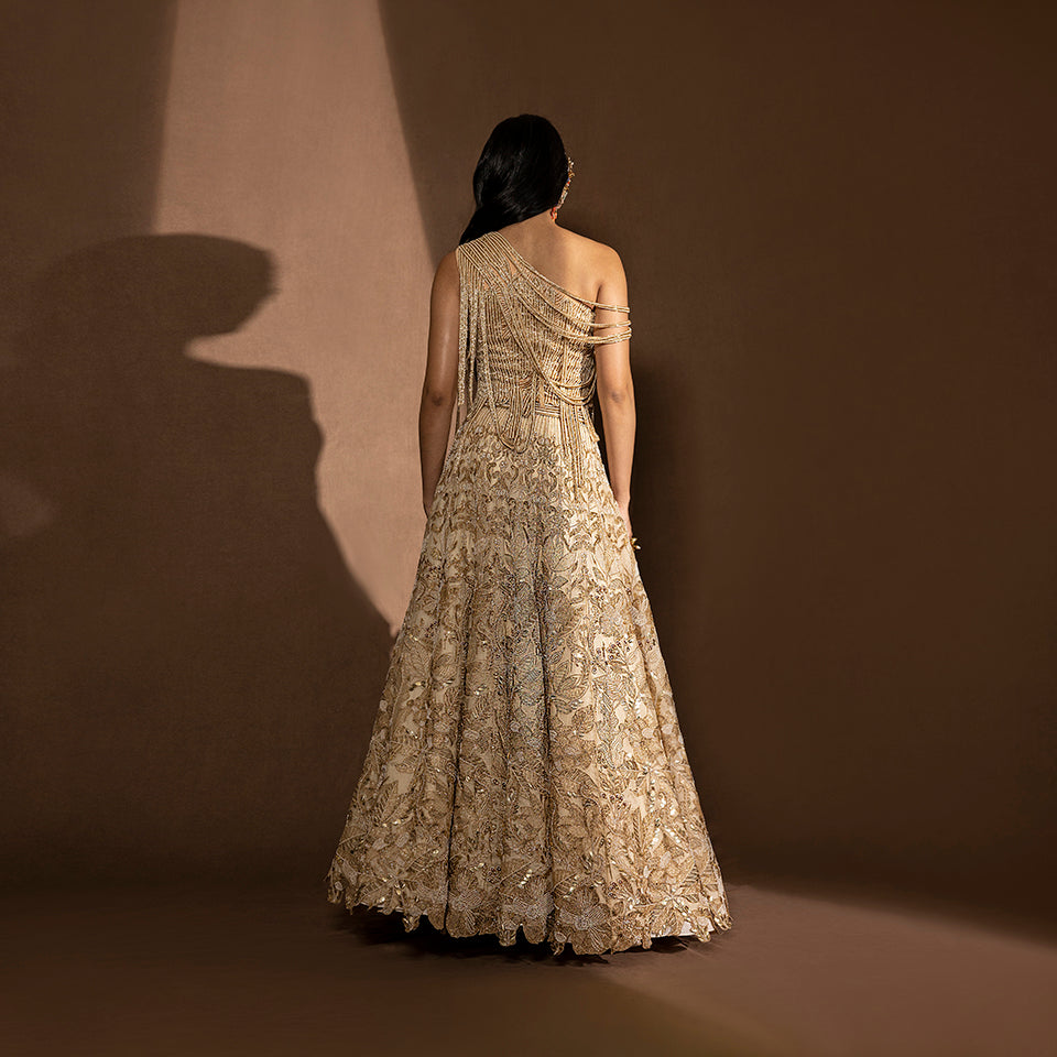 back view of Women's gold bridal lehenga with intricate embroidery and back-draped one-shoulder blouse – designer wedding ensemble, sangeet look