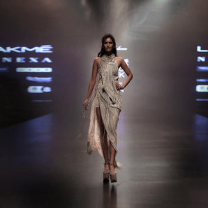 runway view of Women's halter-neck draped gown with asymmetric slit and textural fringe layers for red carpet evenings