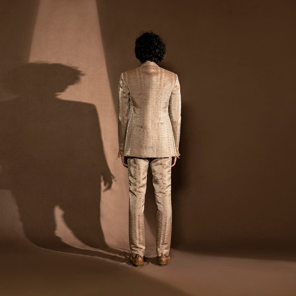 Men's back view of metallic pleated one-button suit – structured minimalist cocktail wear, modern designer menswear