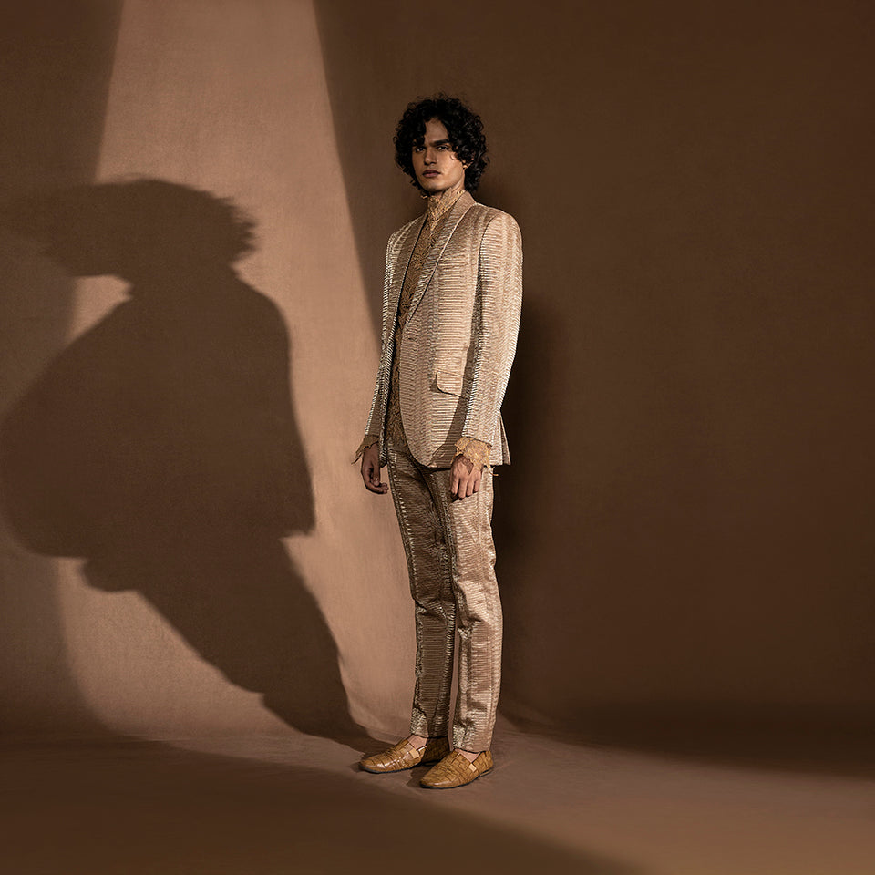 Men's side view of metallic pleated one-button suit with lace detailing – minimalist formal cocktail look, designer menswear