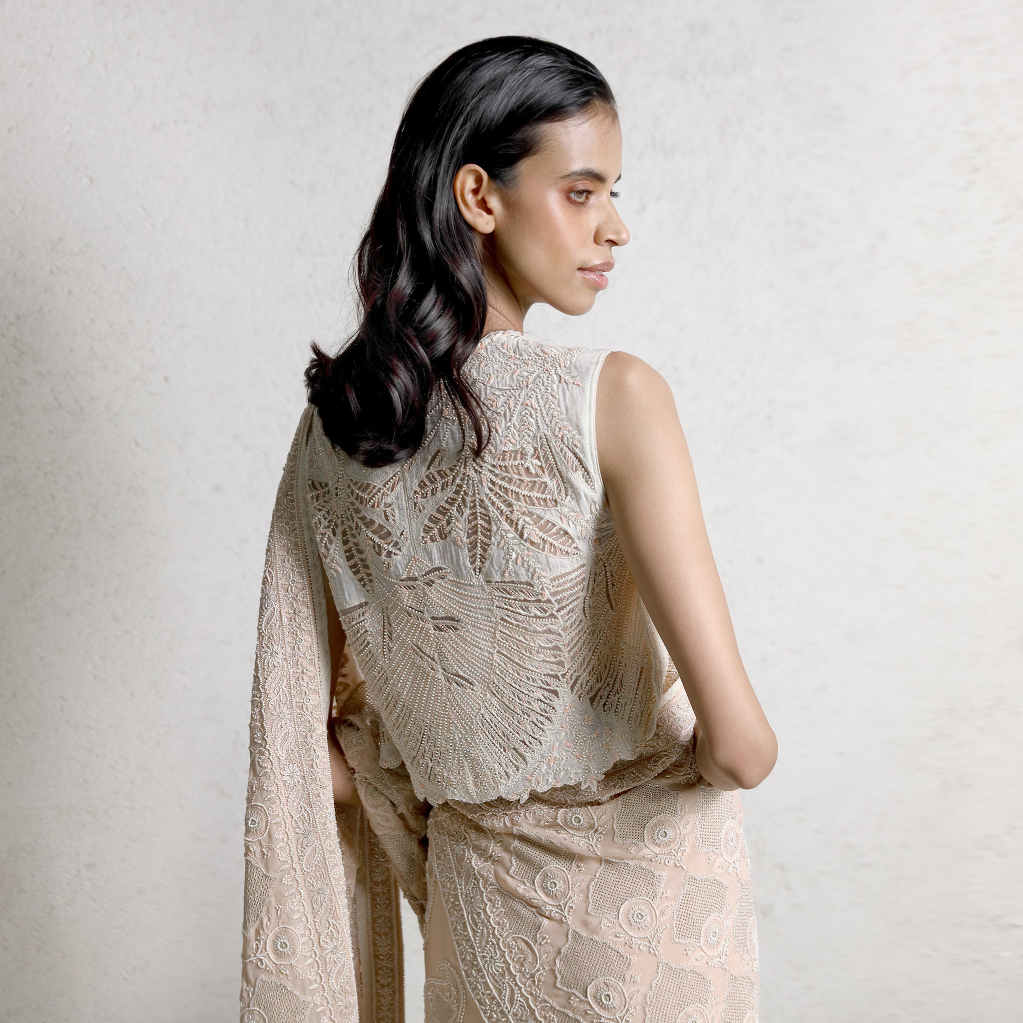 upperback view of Women's chikankari saree with circular jaali motifs paired with embroidered leaf-pattern blouse – detailed artisanal couture for festive wear