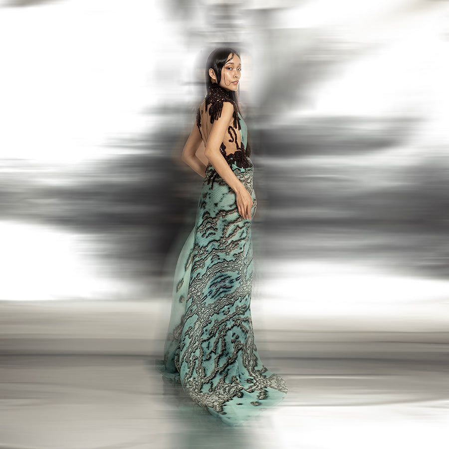 full body side view of Women's reef printed asymmetrical couture gown with open back and artistic drape – textured statement piece for cocktail or red carpet