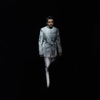 runway shot of Men's sculpted Bandhgala with tonal silk yarn embroidery – contemporary fusion suit with 3D texture, showcased on runway for high-fashion cocktail wear