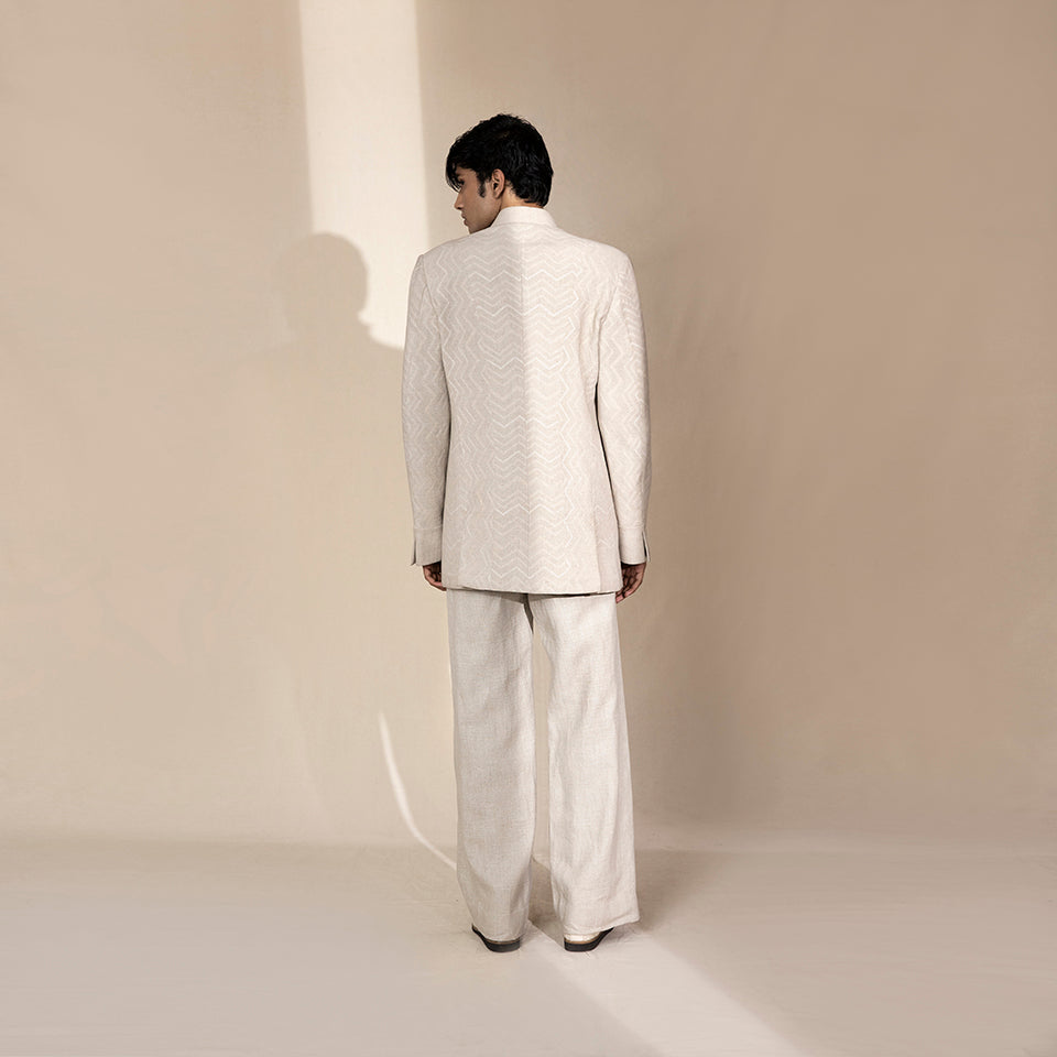 Men's ivory Bandhgala suit with tonal chevron texture and structured longline back – minimal Indian festive ensemble